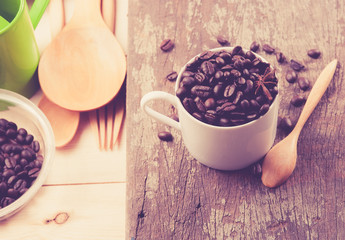 Coffee beans in cup on wood background,selective focus