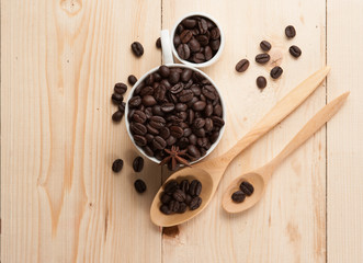 Coffee beans in cup on wood background,selective focus, retro fi
