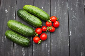 delicious fresh cucumbers and cherry tomatoes lie on a wooden table. Correct and healthy food