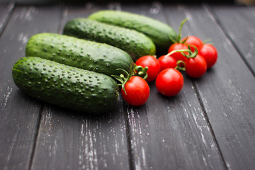 delicious fresh cucumbers and cherry tomatoes lie on a wooden table. Correct and healthy food