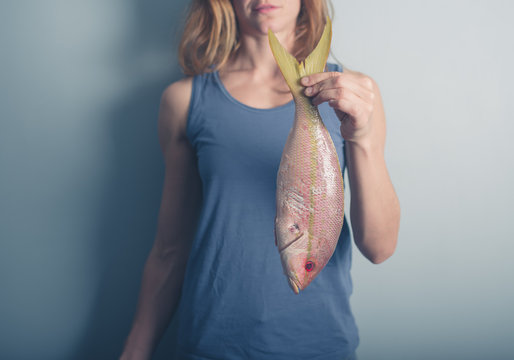 Young woman holding exotic fish