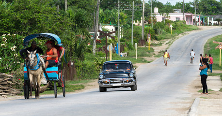 Kuba schwarzer amerikanischer Oldtimer fährt auf der Landstrasse im Landesinneren mit Ansicht Strassenleben