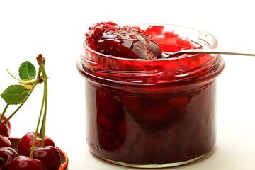 cherry jam in a jar on a white background
