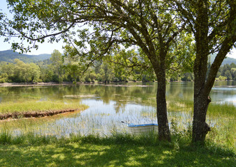 Fototapeta na wymiar Lake with rowboat on the bank