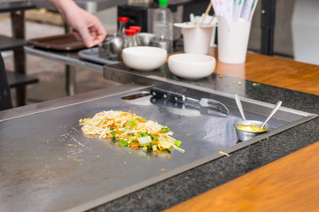 Chef seasoning freshly cooked Asian stir fry