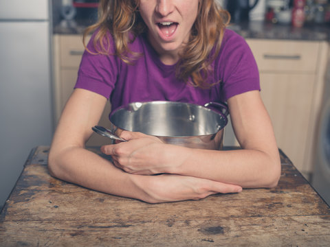 Happy woman with pot in kitchen