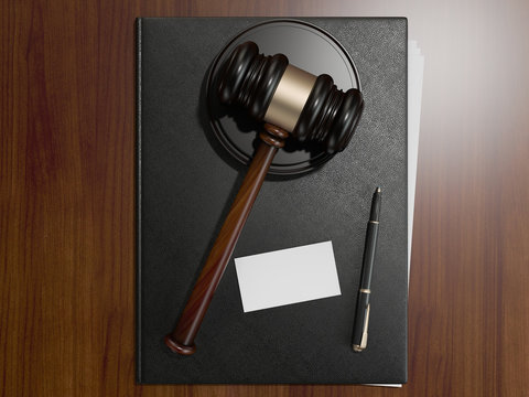 Wooden judges gavel and leather folder on the brown wooden background