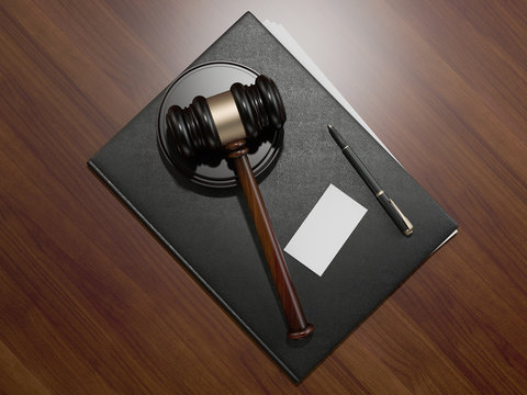 Wooden judges gavel and leather folder on the brown wooden background