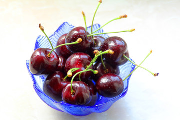 The dark red cherries in the blue bowl