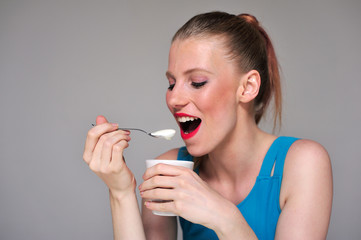 Young woman eating her yogurt