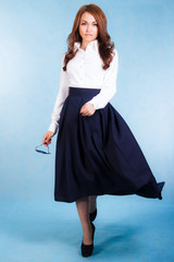 Fototapeta premium Beautiful young woman in a white shirt and a long blue skirt