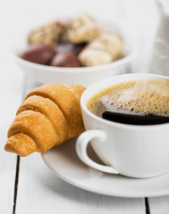 Hot cappuccino and pastries on white wooden boards