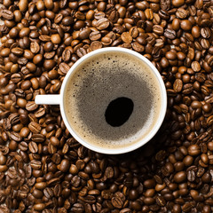 cup of hot coffee on coffee beans background