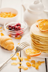 delicious pancakes on wooden table with fruits