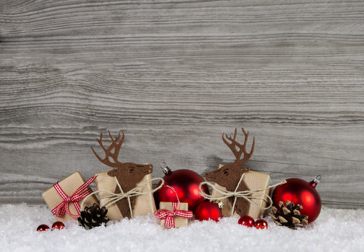 Winterlicher Holz Hintergrund zu Weihnachten mit Geschenke und Rentiere oder Elche.
