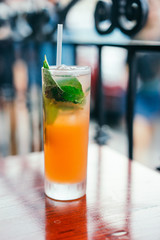 Orange cocktail with mint leaves outdoors