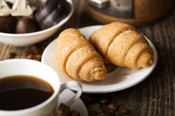 Hot coffee and pastries on a wooden background, view from the top