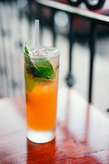 Orange cocktail with mint leaves outdoors