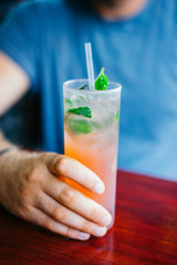 Young man is drinking cocktail outdoors
