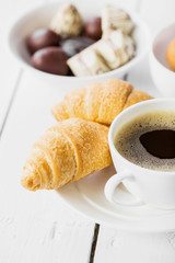 Hot cappuccino and pastries on white wooden boards