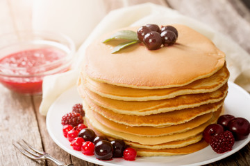 delicious pancakes on wooden table with fruits