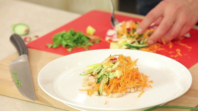 Chef is Putting Freshly Cut Vegetables on a Plate for Vegetarian Salad