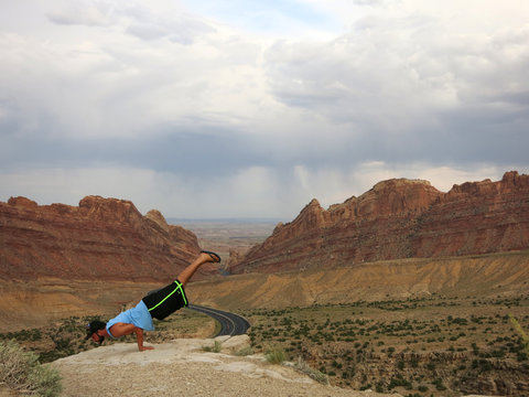 Man does balances on hands as he does Mayurasana or Peacock Pose