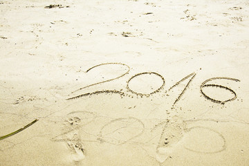 Numbers 2016 and 2015 written in sand