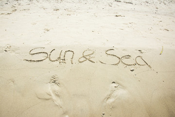 Sun and sea written in sand