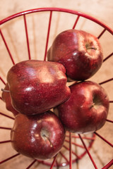 Overhead view of Red Delicious Apples in a red wire basket