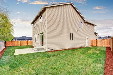 Obraz premium fenced and unfurnished back yard with grass.