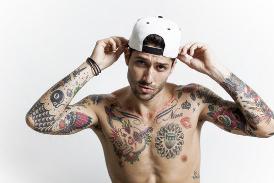 Handsome tattooed man portrait wearing baseball cap and posing
