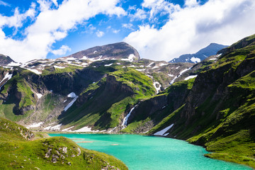 Naklejka na ściany i meble beautiful turquoise lake below the high mountains