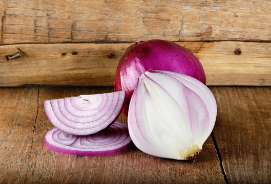 Red onion on the wooden background