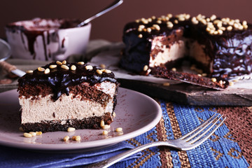 Delicious chocolate cake with icing in plate on table, closeup
