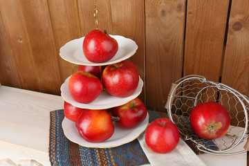 Tasty ripe apples on serving tray on wooden background