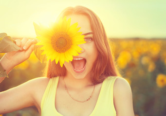 Beauty joyful teenage girl with sunflower