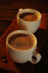 Cups of coffee on napkin on table close up