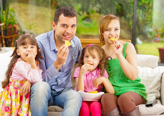 Family portrait of father, mother and two daughters sitting