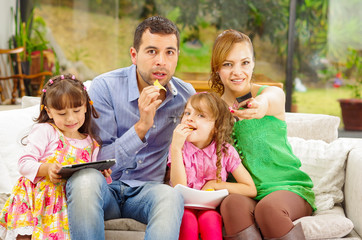 Fototapeta premium Family portrait of father, mother and two daughters sitting