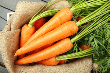 Fresh organic carrots on sackcloth, closeup