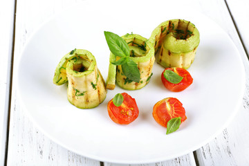 Grilled rolls of vegetable mallow in white plate on table, closeup