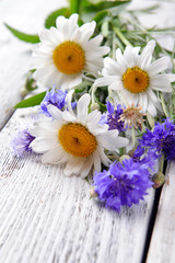Fototapeta na wymiar Fresh wildflowers on wooden table, closeup
