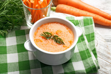 Carrot cream-soup with vegetables on table close up