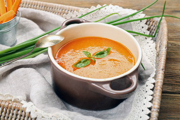 Carrot cream-soup with vegetables on table close up