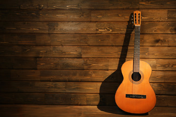 Classical guitar on wooden background - obrazy, fototapety, plakaty