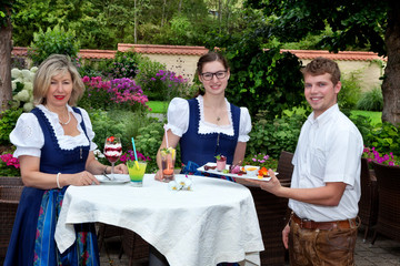 Kellner bedient 2 Frauen im Dirndl Porträt