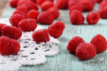 Fresh raspberries on wooden table with napkin, closeup