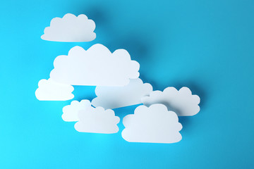 White paper clouds on blue background. Cloud computing concept.