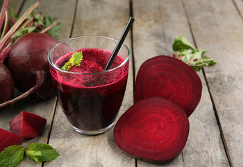 Glass of beet juice on wooden table, closeup